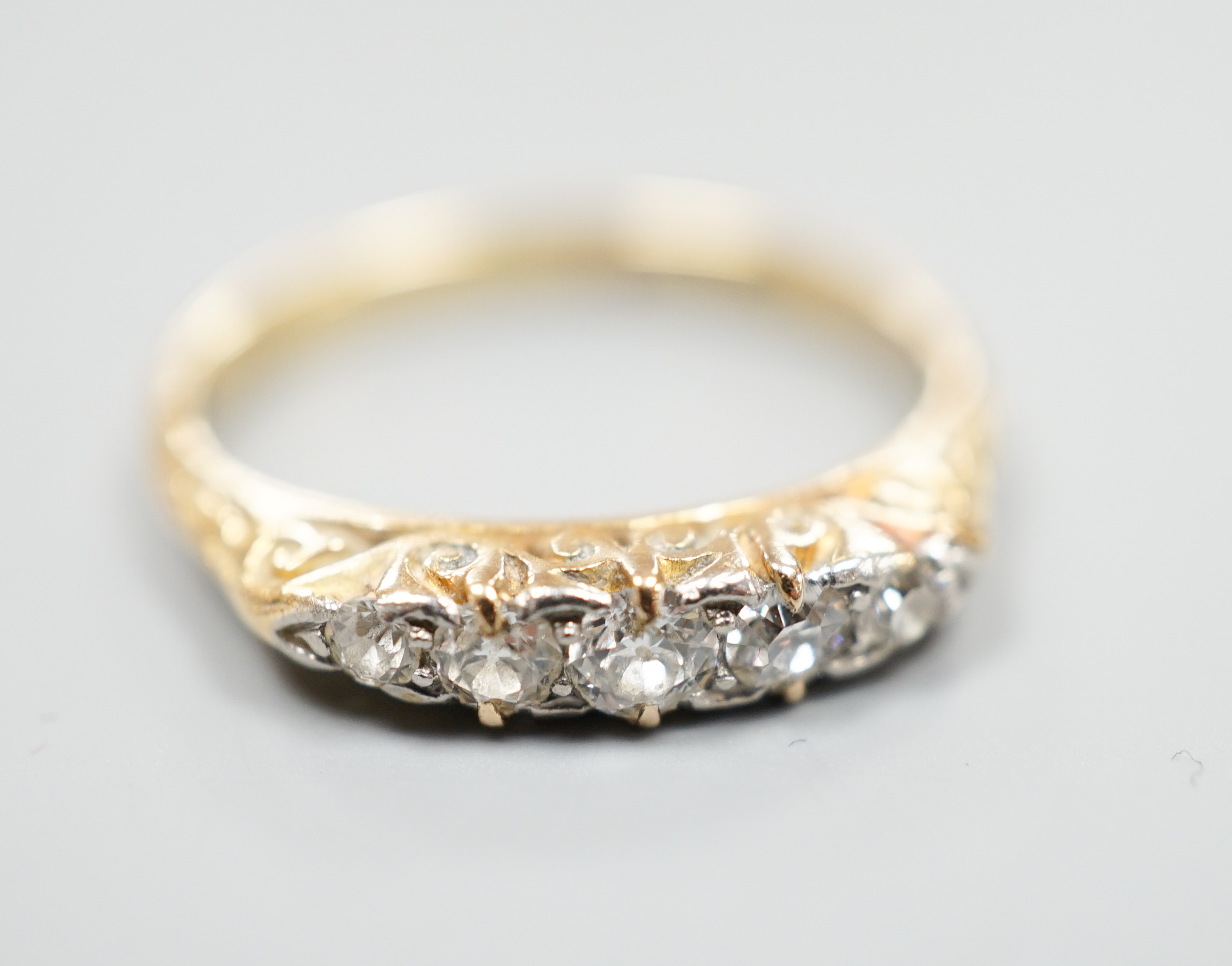 An 18ct and graduated five stone diamond set half hoop ring, size O, gross weight 3 grams.